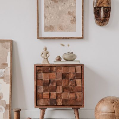 Elegant comosition of masculine room decor with small wooden cupboard, two mockup paintings and vintage accessories. Home staging. Template. Copy space.